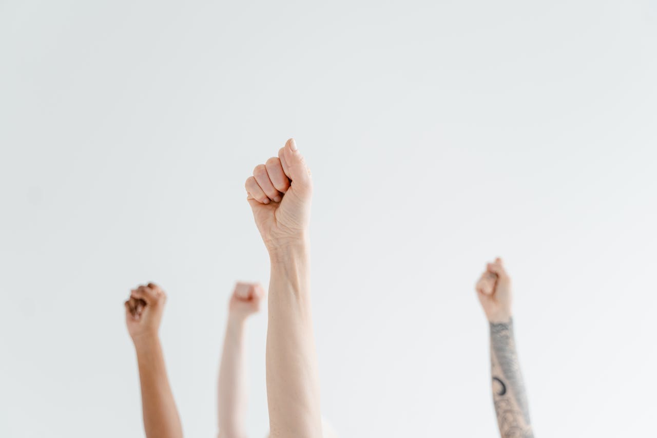 brand-02 A group of diverse hands raised in solidarity, representing unity and empowerment.